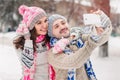 Couple in love making selfie on winter outdoors in sweaters, scarf and mittens Royalty Free Stock Photo