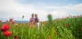 couple in love of man with guitar and woman in summer poppy flower field, kiss