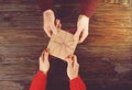 Couple in love. Man hold woman`s hand top view image on wooden background.
