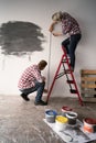 Couple in love measuring the walls in a room. Tape measure and pencil in women's hands. Couple measuring wall in new