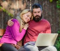 Couple in love notebook consume content. Couple with laptop sit bench in park nature background. Surfing internet Royalty Free Stock Photo