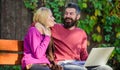 Couple in love notebook consume content. Surfing internet together. Couple with laptop sit bench in park nature Royalty Free Stock Photo