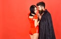 Couple in love, perfect match. Vampire in cloak and devil girl holds hands. Couple on pensive faces play role game Royalty Free Stock Photo