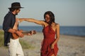 Couple in Love Playing Guitar and Dancing on the Beach Royalty Free Stock Photo