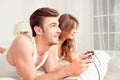 Couple in love playing video games in bedroom, side view Royalty Free Stock Photo