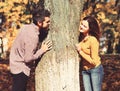 Couple in love plays behind tree in autumn park. Royalty Free Stock Photo