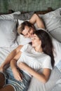 Young attractive smiling girl and guy lying in bed Royalty Free Stock Photo