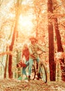 Couple in love ride bicycle together in forest park. Bearded man and woman relaxing in autumn forest. Romantic couple on