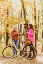 Couple in love ride bicycle together in forest park. Friends with bicycle. Bearded man and women relaxing in autumn