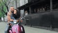 Couple in love riding a motorcycle on a city street.