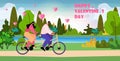 couple in love riding tandem bicycle celebrating happy valentines day in park landscape background Royalty Free Stock Photo