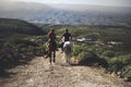 Couple in love riding two beautiful horses stay together in a travel adventure for alternative lifestyle and vacation.