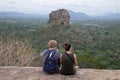 The couple in love on a rock admires the beautiful views at Pidurangala mountain