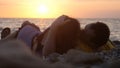 Couple in love romantically lay under the sun kissing together during amazing sunset Royalty Free Stock Photo