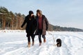 Couple in love running on winter beach with puppy dog Royalty Free Stock Photo