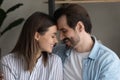 Couple in love sit on couch touch foreheads enjoy moment