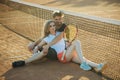 Couple in love sit at tennis net on clay court Royalty Free Stock Photo