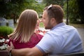 Couple in love is sitting on a bench. Man and woman enjoy each other`s conversation in the summer park Royalty Free Stock Photo