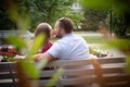 Couple in love is sitting on a bench. Man and woman enjoy each other`s conversation in the summer park Royalty Free Stock Photo