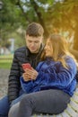 Couple in love sitting on a bench in a public park