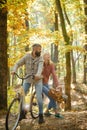 Couple in love sitting at bicycle at autumnal forest. Sunny sweater weather and good vibes. Lovers cycling at autumn Royalty Free Stock Photo