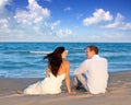 Couple in love sitting in blue beach