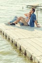 Couple in love sitting on the pier, embrace Royalty Free Stock Photo
