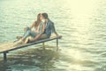 Couple in love sitting on the pier, embrace Royalty Free Stock Photo