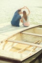 Couple in love sitting on the pier, their hands show heart Royalty Free Stock Photo