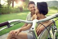 Couple in love sitting together on a bench with bikes