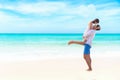 Couple in love. Smiling asian young man is holding girlfriend in his arms on the beach on evening time, blue sky heart shape backg Royalty Free Stock Photo