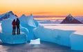 A couple in love standing on an ice floe among the ice and admiring the sunset Royalty Free Stock Photo