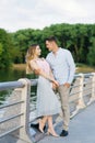 Couple in love are standing on the lake at the railing, hugging and smiling at each other on the first date. Valentine`s day Royalty Free Stock Photo