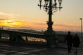 Couple in love is standing on the liberty bridge over the river Danube in Budapest. Sunrise in the big city. Man and woman are Royalty Free Stock Photo