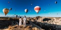 A couple in love stands against the background of balloons in Cappadocia, panorama. Travel to the tourist places of Turkey.