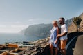 A couple in love stands on an observation deck against the backdrop of the Acantilados de Los Gigantes mountains at