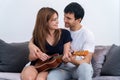 Couple in love. Stunning sensual portrait of young couple indoors. Attractive young man playing ukulele for his beloved