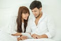 couple in love useing tablet together on the white bed in bedroom