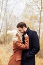 Couple in love walking in the autumn Park, cool fall weather. A man and a woman embrace and kiss, love and affection yellow autumn Royalty Free Stock Photo