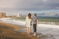 Couple in love walking on the beach on sunny day. Stylish hipsters near the waves on the sea. Man and woman hugging and kissing. Royalty Free Stock Photo