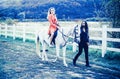 Couple in love walking with horse on countryside. Romantic love story of sensual couple. Woman riding grey arabian horse Royalty Free Stock Photo