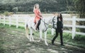 Couple in love walking with horse on countryside. Romantic love story of sensual couple. Woman riding grey arabian horse Royalty Free Stock Photo