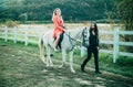 Couple in love walking with horse on countryside. Romantic love story of sensual couple. Woman riding grey arabian horse Royalty Free Stock Photo