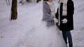 A couple in love is walking through a snowy winter forest. Lovers are wearing warm scarves. A young man takes care of his girlfrie