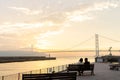 Couple in love watching sunset together on ocean travel summer holidays. People silhouette from behind sitting enjoying view Royalty Free Stock Photo