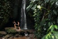 A couple in love on a waterfall. Honeymoon trip. Happy couple on the island of Bali. Beautiful couple travels the world. Royalty Free Stock Photo