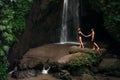 A couple in love on a waterfall. Honeymoon trip. Happy couple on the island of Bali. Beautiful couple travels the world. Travel Royalty Free Stock Photo