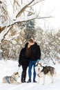 Couple in love in the winter sunny forest with dogs Royalty Free Stock Photo