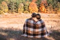 Couple in love wrapped in plaid outdoors.