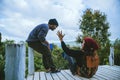 Couple lover natural travel on the mountain, sitting relax reading books in the midst of nature on the white wooden bridge